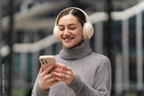 Scrolling, sharing, staying connected. A woman with headphones and smartphone reacts to social media updates, capturing real-time engagement in a world driven by digital connections