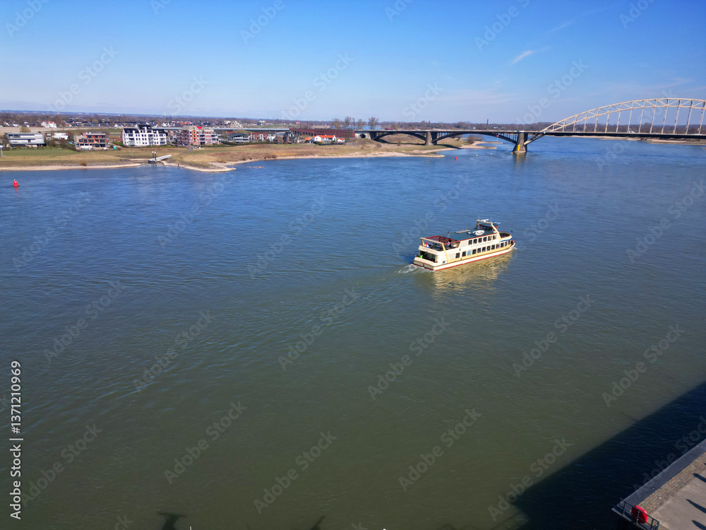 Fototapeta premium Nijmegen Serenity: River Reflections Under a Vast Blue Sky.