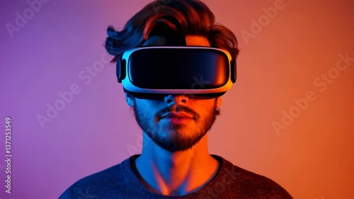 Young adult male wearing virtual reality glasses on a background illuminated with different colors. Perfect for advertisements.