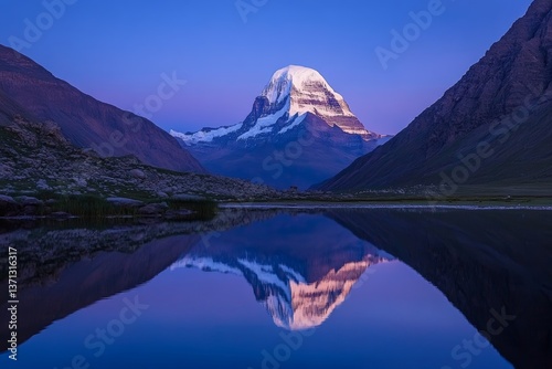 A beautiful mountain range at dusk, with the snow-capped Mount Kailash in the background and reflecting on the water, symbolizing peace of mind and spiritual enlightenment
