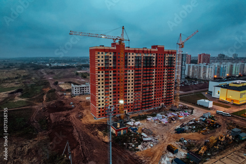 Construction site background. Hoisting cranes and new multi-storey buildings. Industrial background. Building construction site work against blue sky monolithic technology.