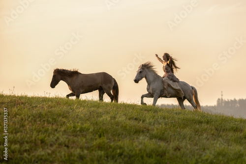 Obraz na płótnie A female equestrian and her horse interacting together. Romantic freedom sunset scene w salonie