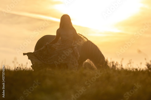 Obraz na płótnie A female equestrian and her horse interacting together. Romantic freedom sunset scene w salonie