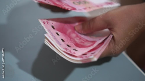 China's economy, Renminbi in global finance or world trade. Counting yuan banknotes Chinese currency (Renminbi or RMB) featuring 100-yuan banknote with Mao Zedong's portrait, slow clip