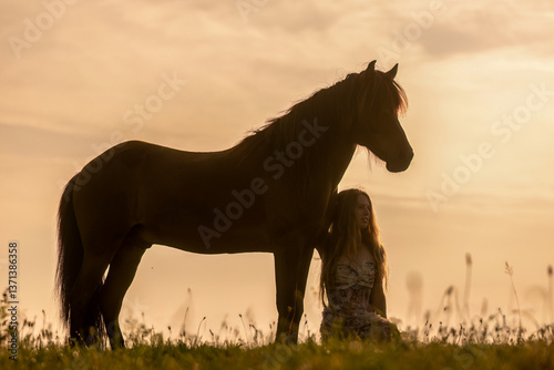 Obraz na płótnie A female equestrian and her horse interacting together. Romantic freedom sunset scene w salonie
