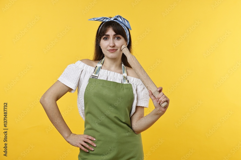 Woman with rolling pin on yellow background Woman with rolling pin on yellow background