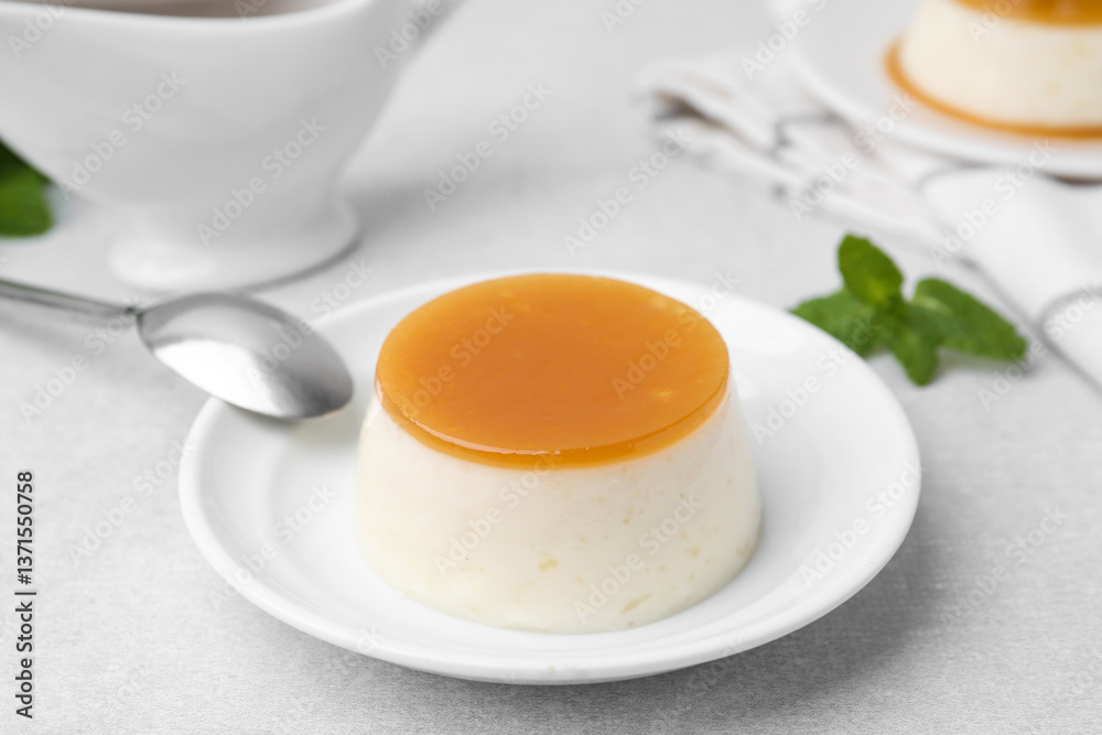 Tasty pudding with caramel sauce served on white table, closeup Tasty pudding with caramel sauce served on white table, closeup