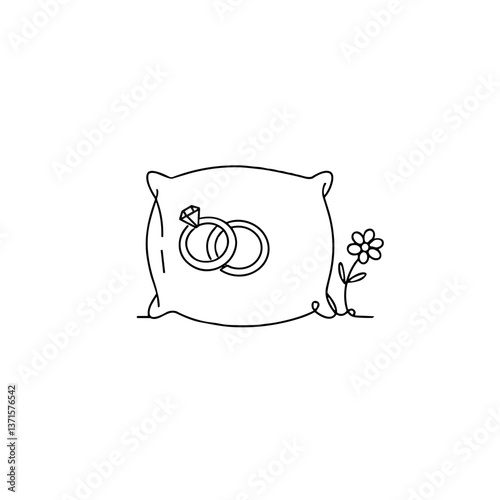 Wedding rings on a decorative pillow surrounded by a flower  