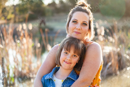 Portrait of happy mother in her thirties with daughter outside