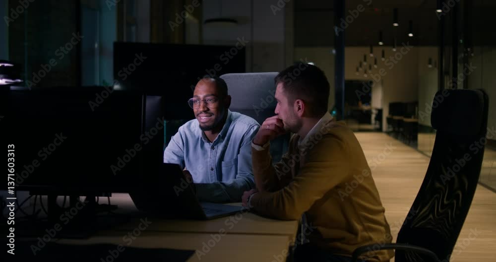 Focused multicultural team collaborating late at night, analyzing data and strategy. Concepts of teamwork, productivity, and business innovation in a modern open space office startup coworking Focused multicultural team collaborating late at night, analyzing data and strategy. Concepts of teamwork, productivity, and business innovation in a modern open space office startup coworking