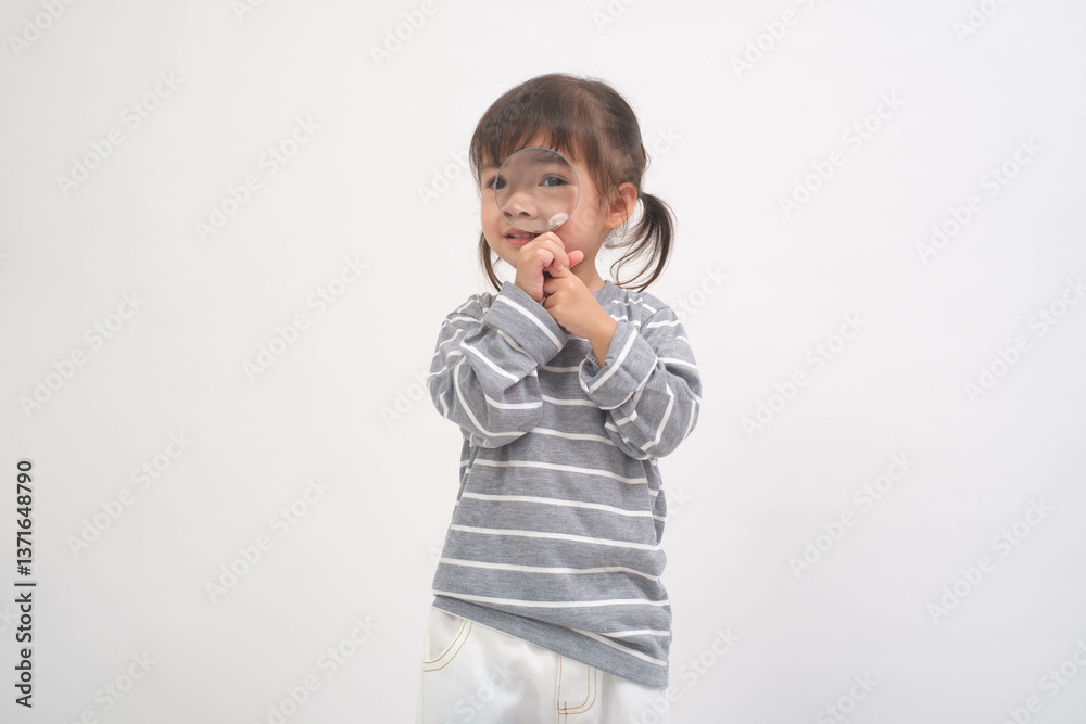 A young child stands playfully against a plain white background, wearing a striped shirt and light pants, capturing a moment of innocence and joy. A young child stands playfully against a plain white background, wearing a striped shirt and light pants, capturing a moment of innocence and joy.