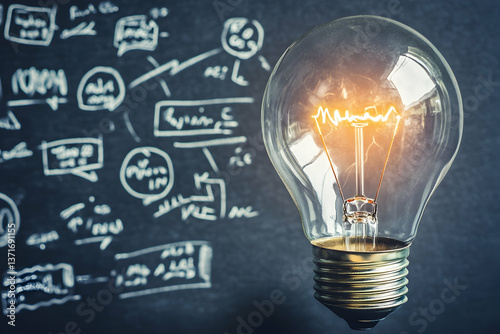 A glowing light bulb in focus with a chalkboard covered in sketches and formulas in the background, representing creativity and problem-solving.