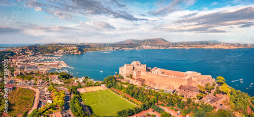 Obraz na płótnie Panoramic view from flying drone of Aragonese Castle of Baia with football stadium, Italy, Europe. Captivating morning seascape of Mediterranean sea. Traveling concept background. w salonie