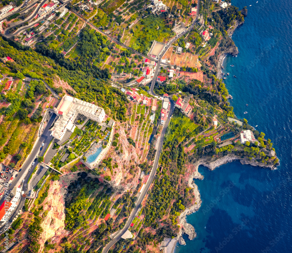 Stright down view from flying drone of Santa Maria di Grado palace, located on the huge cliff on Mediterranean coast of Italy. Nice summer scene of italian countryside. Traveling concept background.