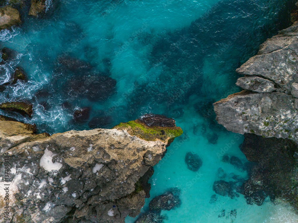 Obraz premium Southwest Sumba, East Nusa Tenggara, Indonesia – 07. 14. 2024 – From above, the dramatic inlet through which Mandorak’s fishing boats pass between giant karst rocks to reach the open waters of South 