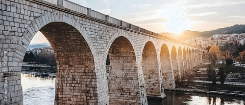 Ancient Stone Arch Bridge at Sunset Over River