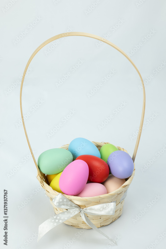 Naklejka premium colorful easter eggs in basket, vertical view, high angle