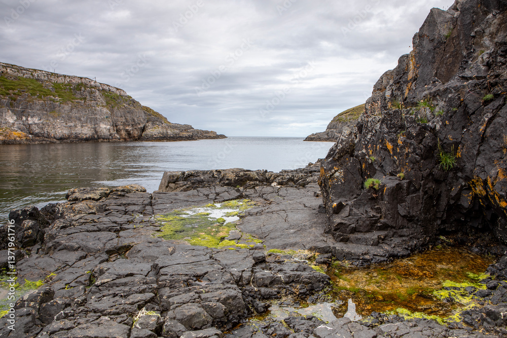 Fototapeta premium The dramatic rocky and slippery shoreline near Smoo cave with the horizon in the background.