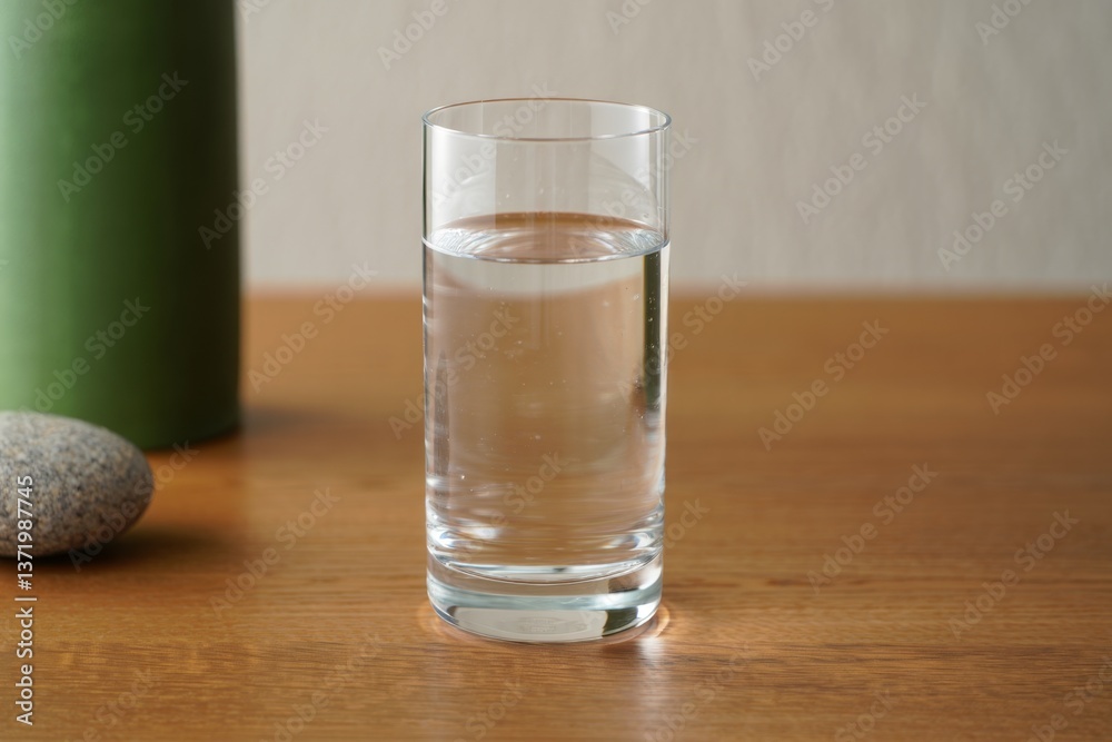 A glass of water sitting on top of a wooden table A glass of water sitting on top of a wooden table