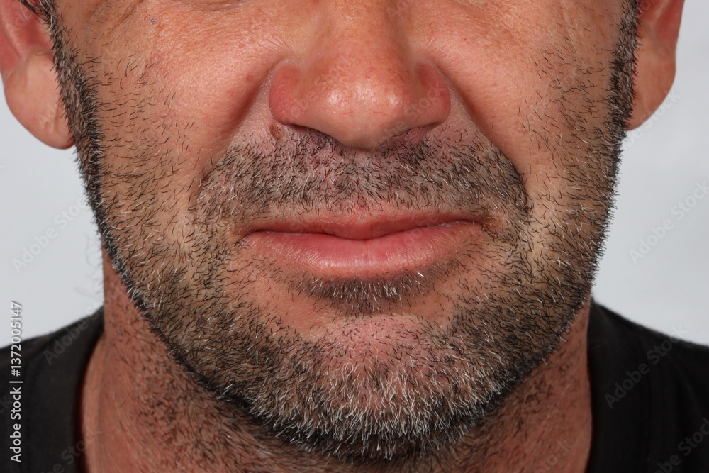 Obraz premium Close-up portrait focused on the lower face of a 45-year-old man, showing slight facial hair and mature skin texture