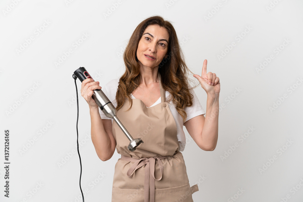 Middle aged caucasian woman using hand blender isolated on white background pointing up a great idea Middle aged caucasian woman using hand blender isolated on white background pointing up a great idea