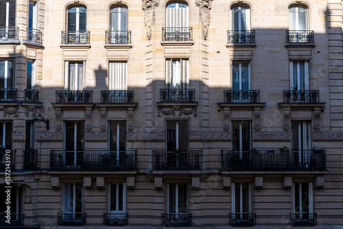 Fototapeta Naklejka Na Ścianę i Meble -  Façade ensoleillée d'immeuble ancien à Paris avec l'ombre de l'immeuble en face