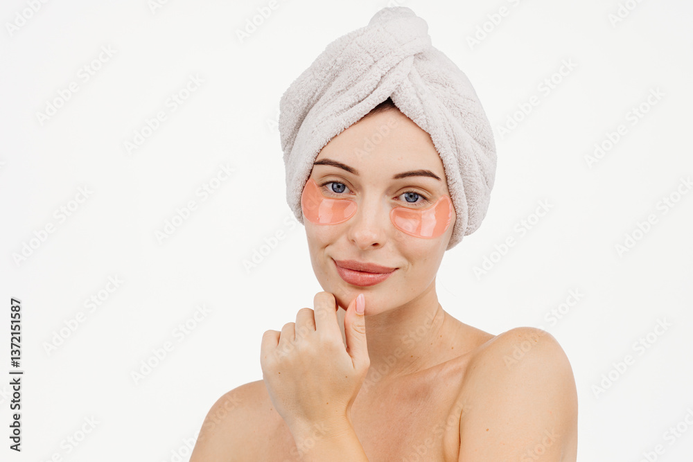 A portrait of a young woman with blue eyes wrapped in a towel after washing her hair. This image captures the essence of spa treatments, self-care, and deep relaxation.