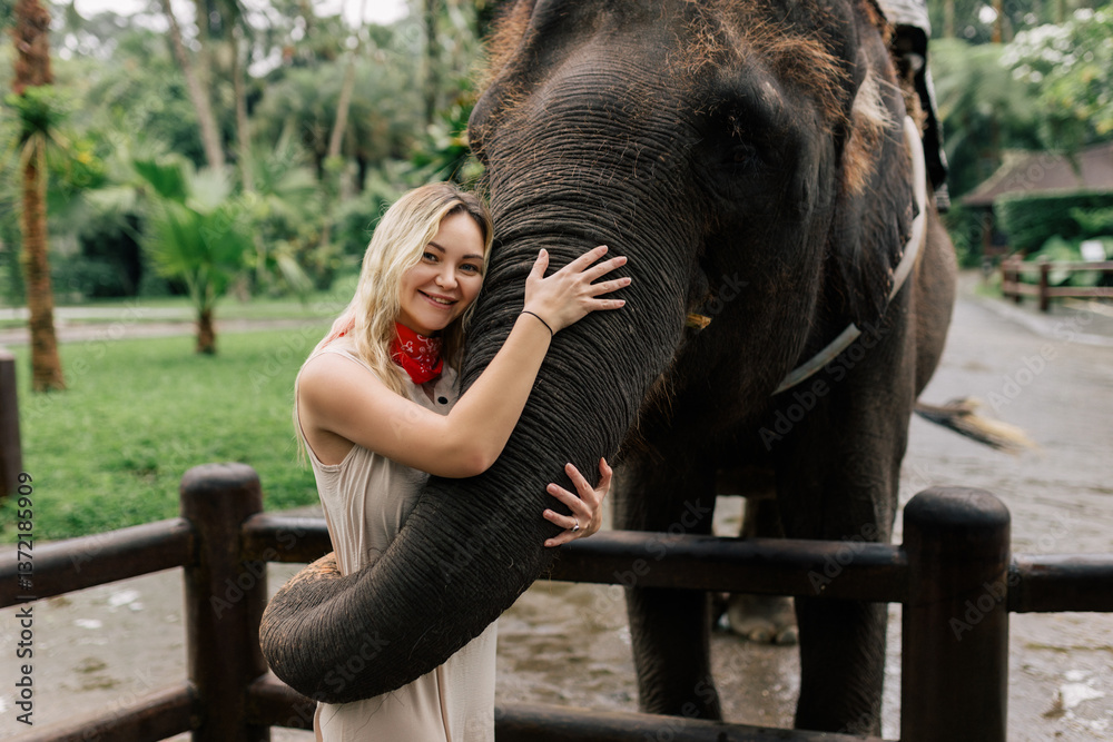 Fototapeta premium beautiful girl with smiling elephant, elephant village, bali
