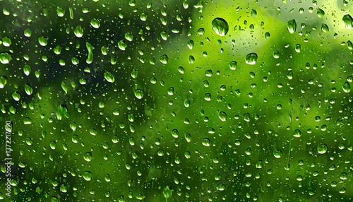 Macro shot of raindrops on a window, each droplet reflecting the soft green hues of the spring garden outside