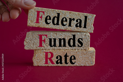 Obraz na płótnie FEDERAL FUNDS RATE symbol. Brick blocks with words FEDERAL FUNDS RATE. Beautiful red background. Businessman hand. Business concept. w salonie