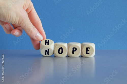 Obraz na płótnie Hope or nope symbol. Male hand turns cubes and changes the word 'nope' to 'hope' on a beautiful blue background. Business and hope or nope concept. w salonie