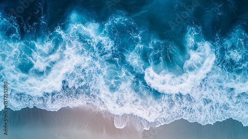 Fototapeta Naklejka Na Ścianę i Meble -  Aerial view of ocean waves crashing onto the shore with white foam and turquoise water surface.