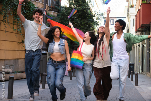 Obraz na płótnie Group of happy multi ethnic friends running along a city street waving rainbow flags at a LGBT pride parade w salonie
