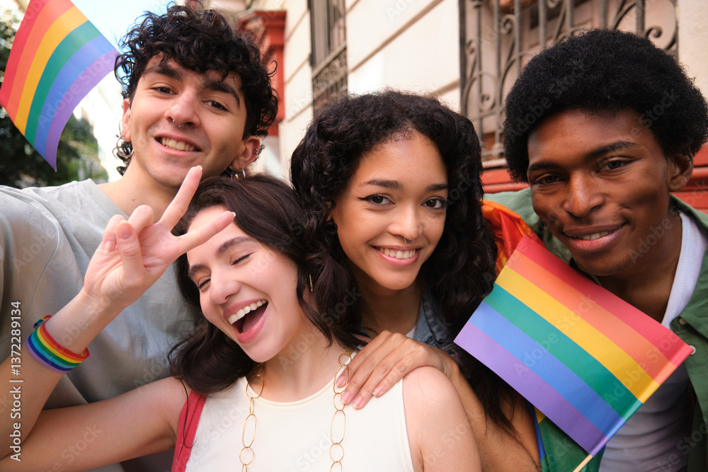Happy multi ethnic friends taking selfie showing rainbow flags at gay pride parade