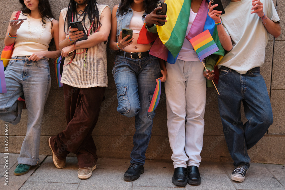 Group of friends using their smartphones and showing rainbow flags