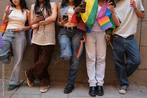 Obraz na płótnie Group of friends using their smartphones and showing rainbow flags w salonie