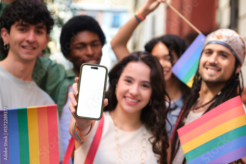 Obraz na płótnie Group of smiling multi ethnic friends celebrating gay pride holding rainbow flags and showing smartphone with blank screen w salonie
