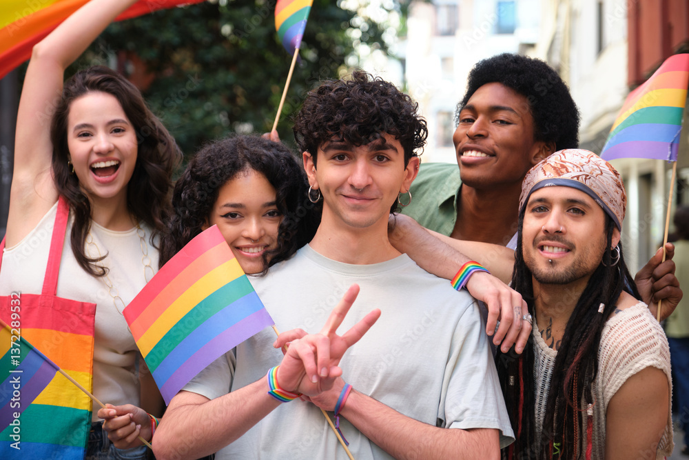 Happy group of young multi ethnic activists showing rainbow flags celebrating gay pride