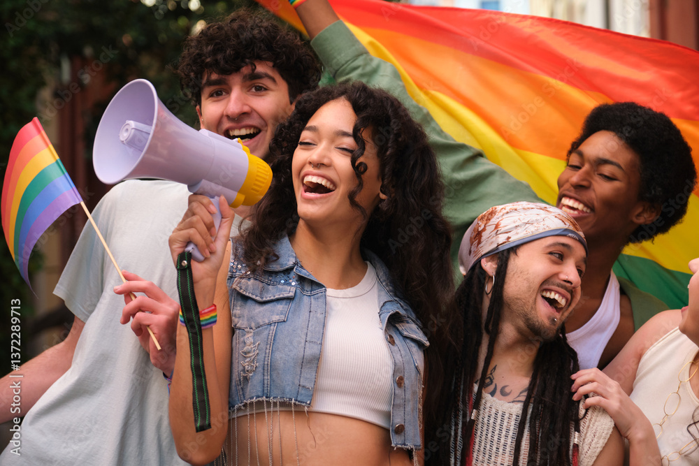 Group of happy multi ethnic activists marching at a lgbt pride parade, holding rainbow flags and shouting with a megaphone