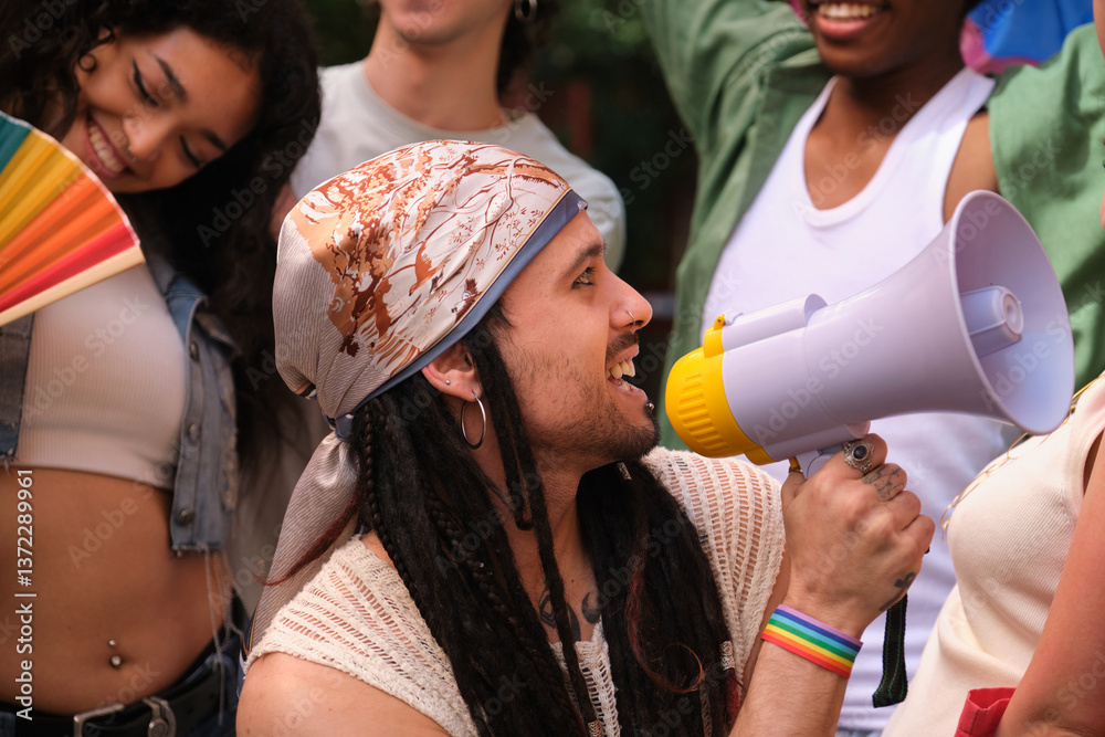 Young man speaking with megaphone at LGBT pride parade promoting equal rights and fighting discrimination