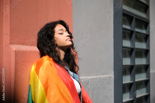 Obraz na płótnie Young woman with closed eyes holding rainbow flag, celebrating LGBT pride and feeling sense of belonging w salonie
