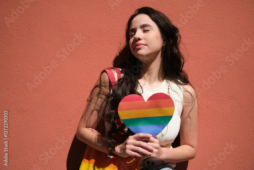 Obraz na płótnie Young woman holding rainbow heart celebrating LGBT pride month w salonie