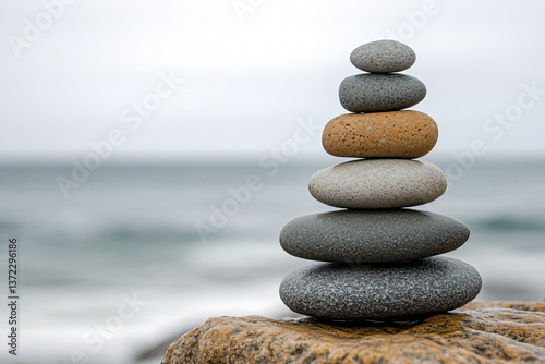 stacked zen stones on beach rock by the sea with calm waves and soft sky, peaceful coastal composition symbolizing balance, mindfulness, and natural harmony in wellness setting
