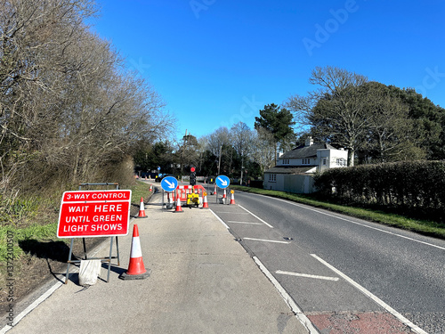 Temporary traffic lights with a when red light shows wait here sign on a residential street.