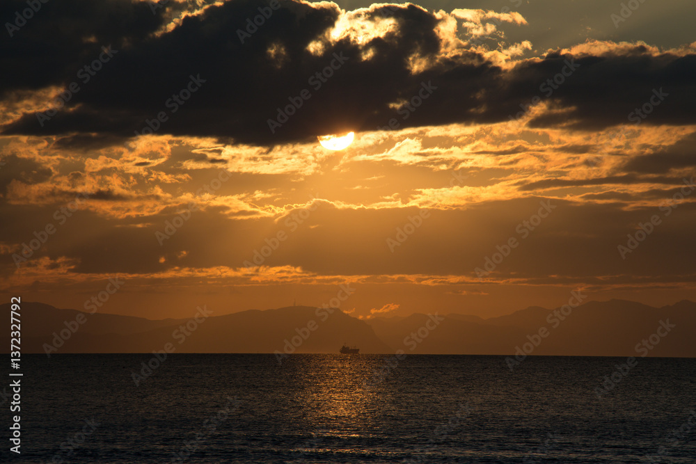 Obraz premium 夕暮れ時の海の水平線に浮かぶ客船の陰影