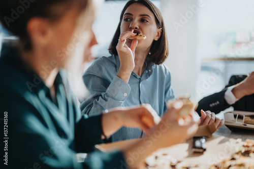 A group of colleagues taking a relaxing break together in the office kitchen. They are engaged in casual conversation while enjoying their meals, fostering a sense of teamwork and camaraderie.