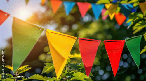 colorful pennant string decoration in green tree foliage on blue sky, summer party background template banner with copy space