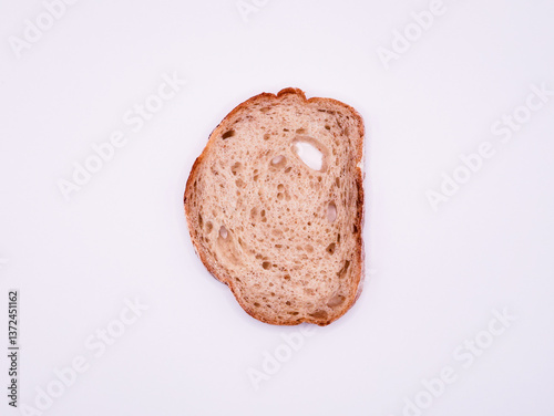 Thin slice of white bread, on a white surface, top view, close-up