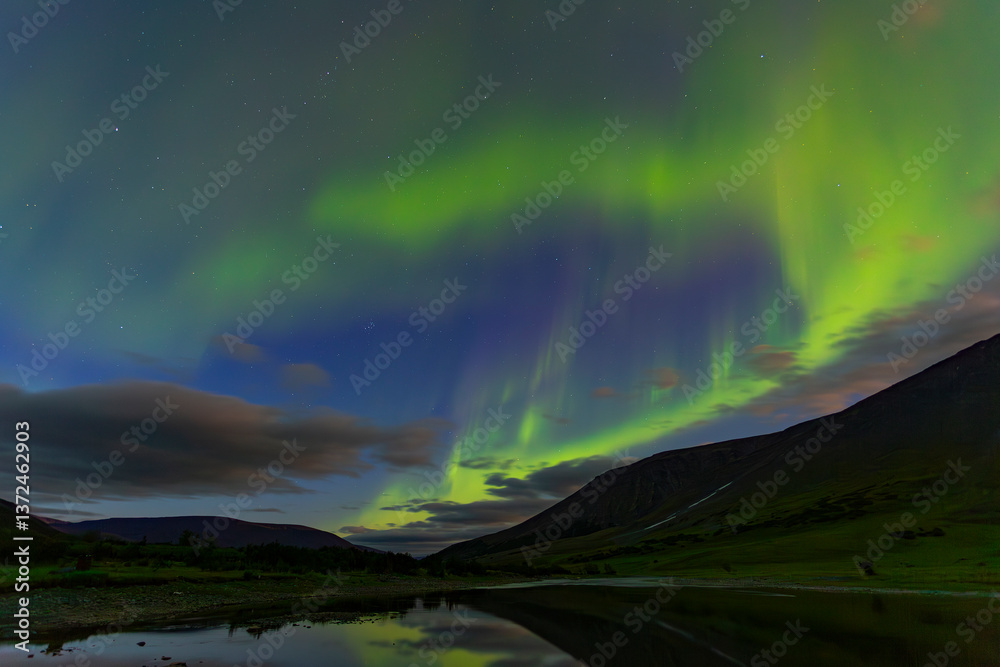 Obraz premium Aurora in the night sky cut the mountains, reflected in the water. Yamal. Russia