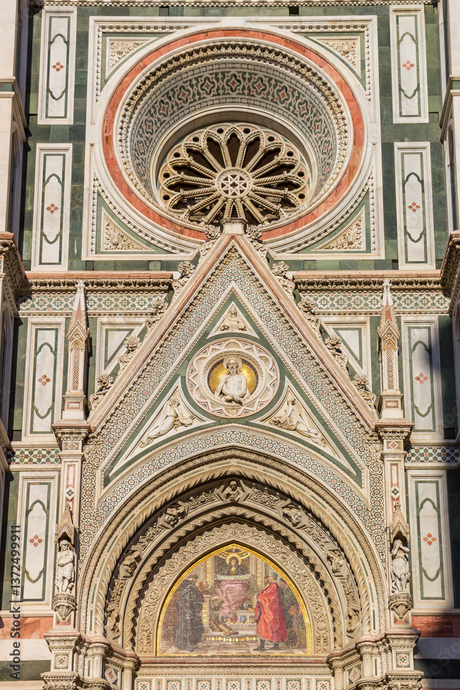 Round window in the front facade of the Duomo cathedral in Florence, Italy